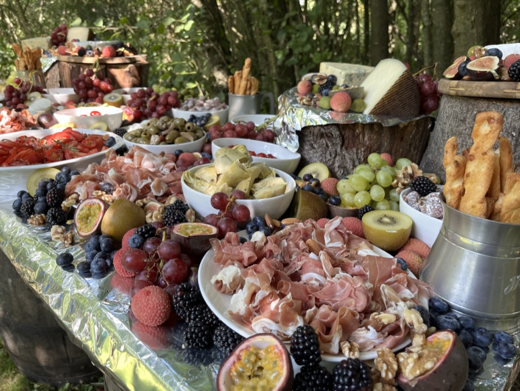 A woodland grazing table at Ruthlin laden with charcuterie, cheeses and fruit
